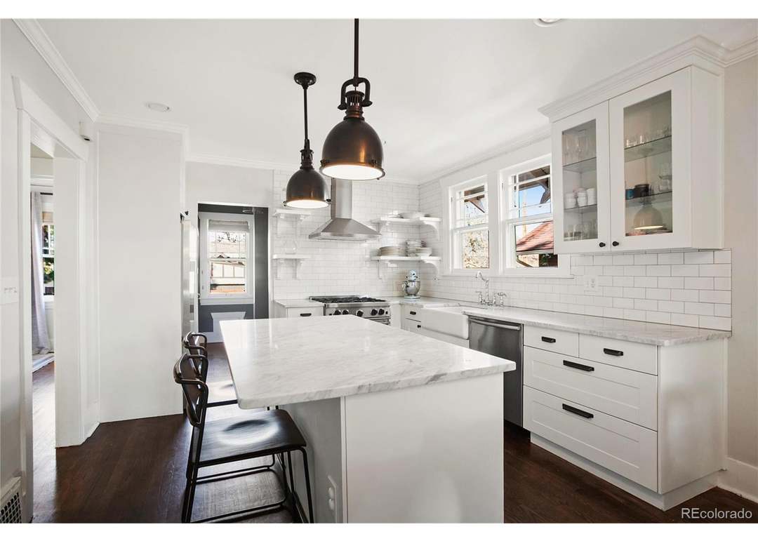 White remodeled kitchen with stone counters and stainless appliances