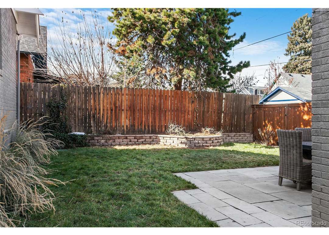 Private fenced backyard with lawn and patio